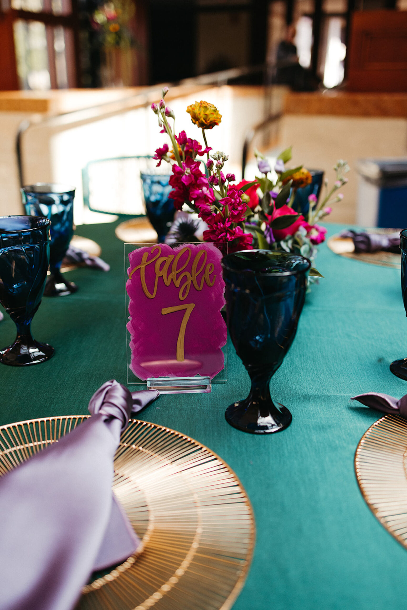 Gold Boho Chargers | Painted Fuchsia Acrylic Table Number Sign Ideas | Blue Goblet Glass Inspiration | Wild Flower Centerpiece Ideas