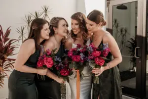 Bridesmaids in Black Bridesmaids Dresses with Dark and Moody Pink and Blue Bouquet Inspiration