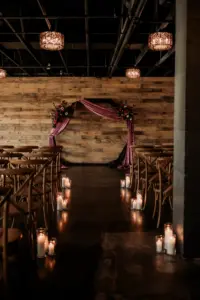 Dark and Moody Wedding Ceremony with Wooden Arch Draped in Purple Velvet, Crossback Chairs, and Pillar Candle Aisle Decor Ideas | Madeira Beach Venue The West Events