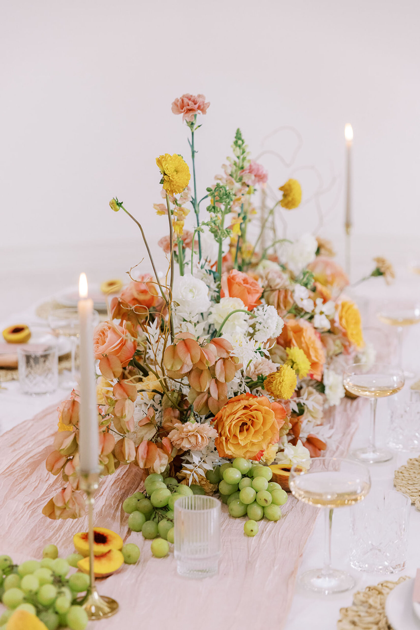 Romantic, Spring-Inspired White, Orange, Yellow, Peach Rose, Dahlias, and Carnation Centerpiece Ideas | Taper Candle with Gold Holder Wedding Reception Inspiration