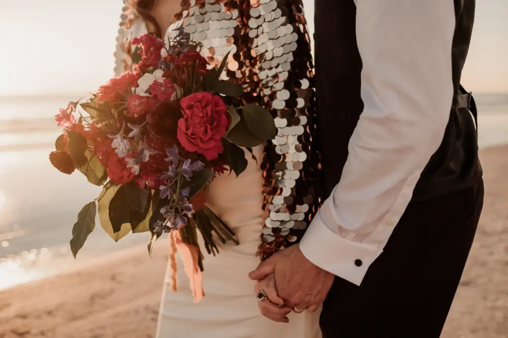 Bright in Sequin Offbeat Bridal Holding Dark and Moody Wedding Floral Bouquet Hand Holding with Groom Wedding Portrait Inspiration