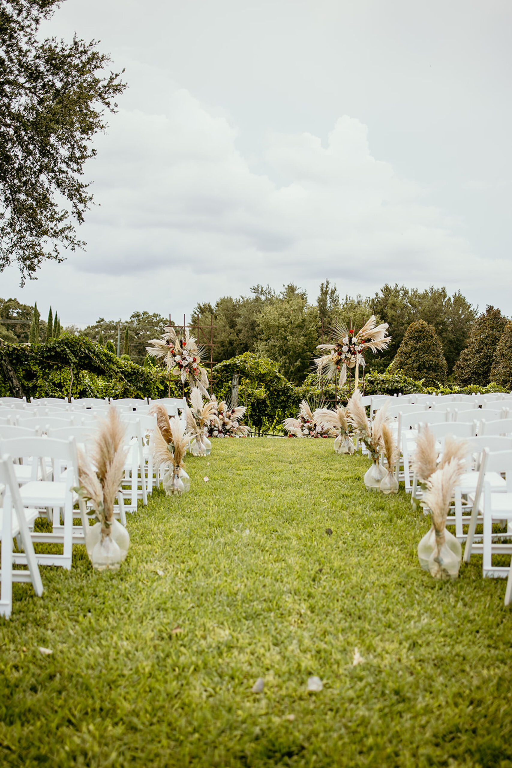 Pampas Grass Aisle Decor Ideas | Boho Rustic Outdoor Wedding Inspiration | White Garden Chairs | Tampa Bay Wedding Venue Mision Lago | Florist Save the Date Florida
