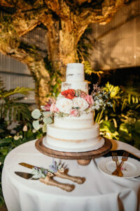 White Five-tiered Semi-Naked Wedding Cake with Red, Pink, and White Roses with Greenery Accents