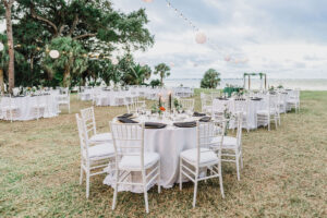 Outdoor Waterfront Wedding Reception with White Chiavari Chairs and String Lights
