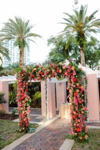 Bright Pink Bougainvillea, Orange and Red Roses, Monstera Wedding Chuppah Floral Arrangement Inspiration