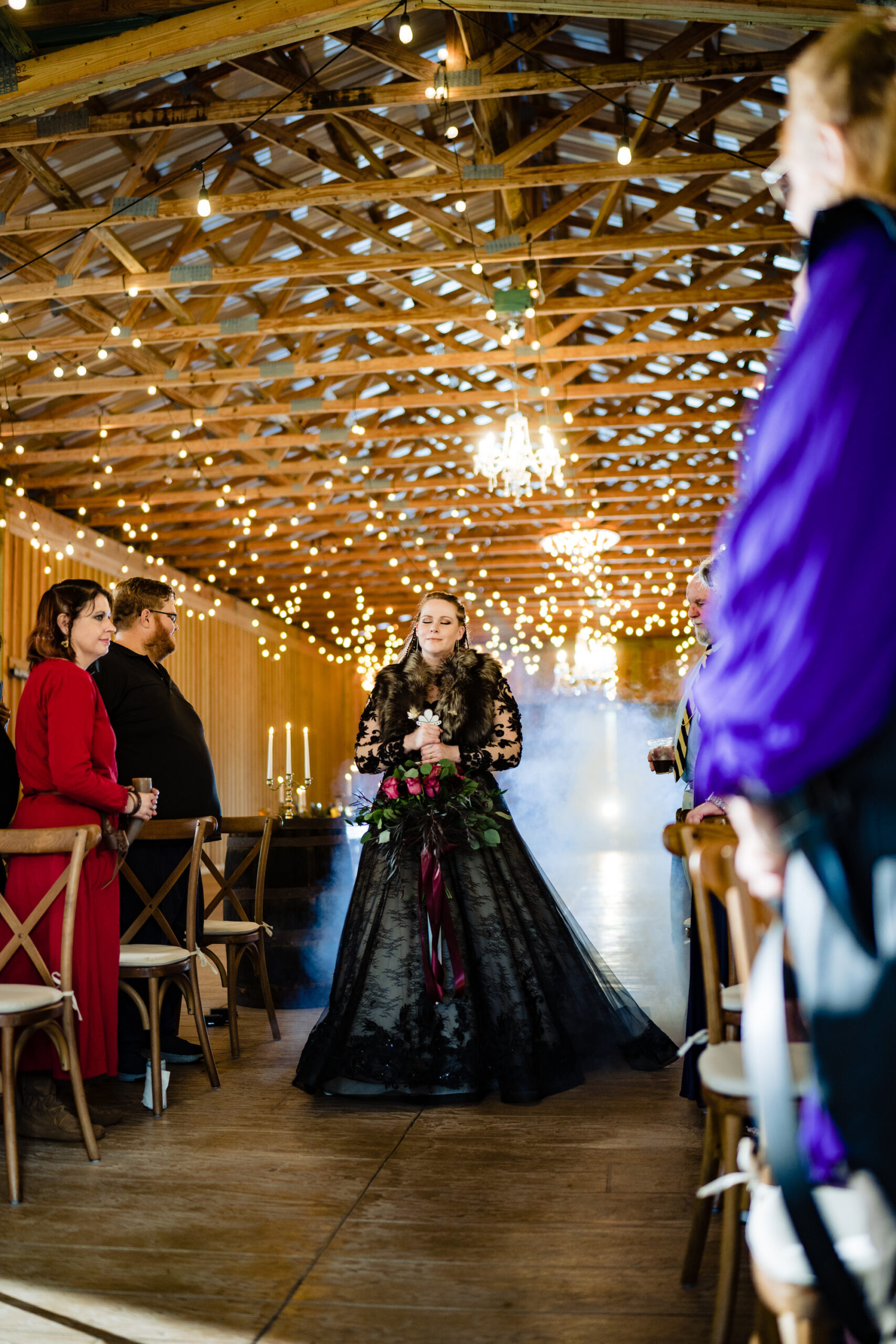 Bride Walking Down Ceremony Aisle in Black Dress | Dark and Moody Viking Themed Wedding Ideas