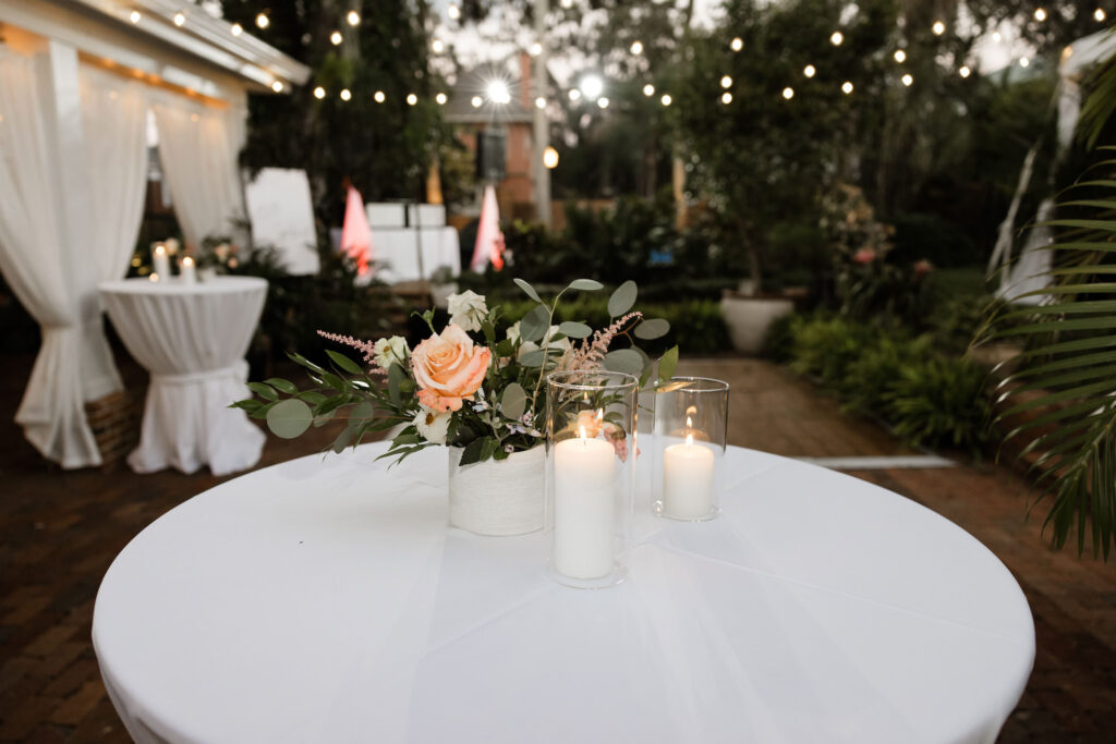 Cocktail Hour Table Decor Ideas | Pillar Candles with Pink ferns, Orange and White Roses with Ruscus and Eucalyptus Table Centerpieces