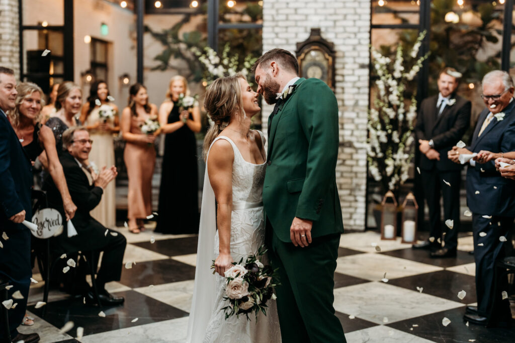 Bride and Groom First Kiss in Dark and Moody Industrial Wedding Ceremony | South Tampa Venue Oxford Exchange | Planner Special Moments