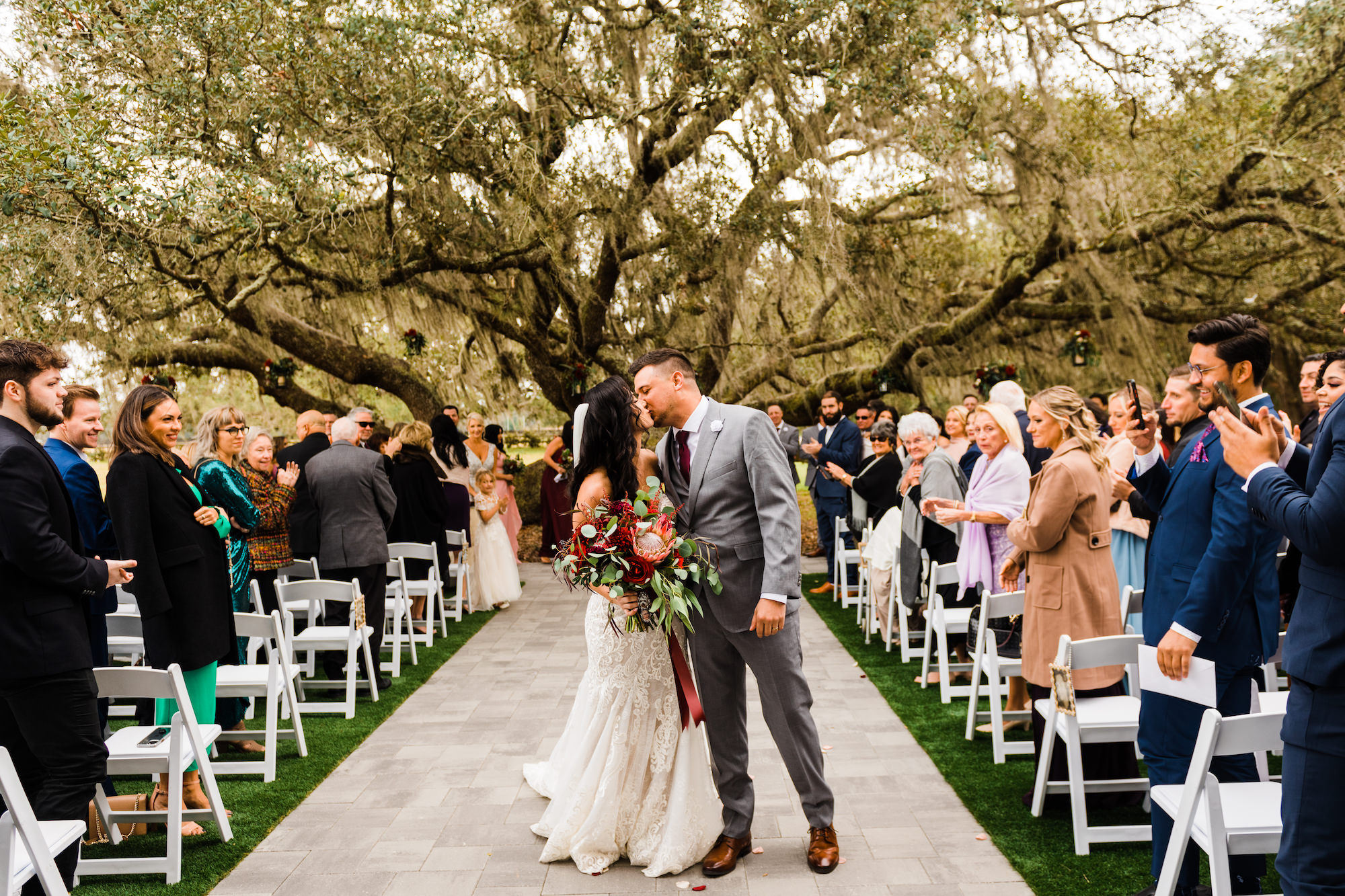 Bride and Groom Kissing In Wedding Aisle | Brooksville Estate Venue Legacy Lane Weddings