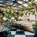 Timeless Industrial Indoor Wedding Reception with Black Crossback Chairs, Candles, and Greenery Tablescape Centerpiece Inspiration | South Tampa Wedding Planner Special Moments | Venue Oxford Exchange Conservatory