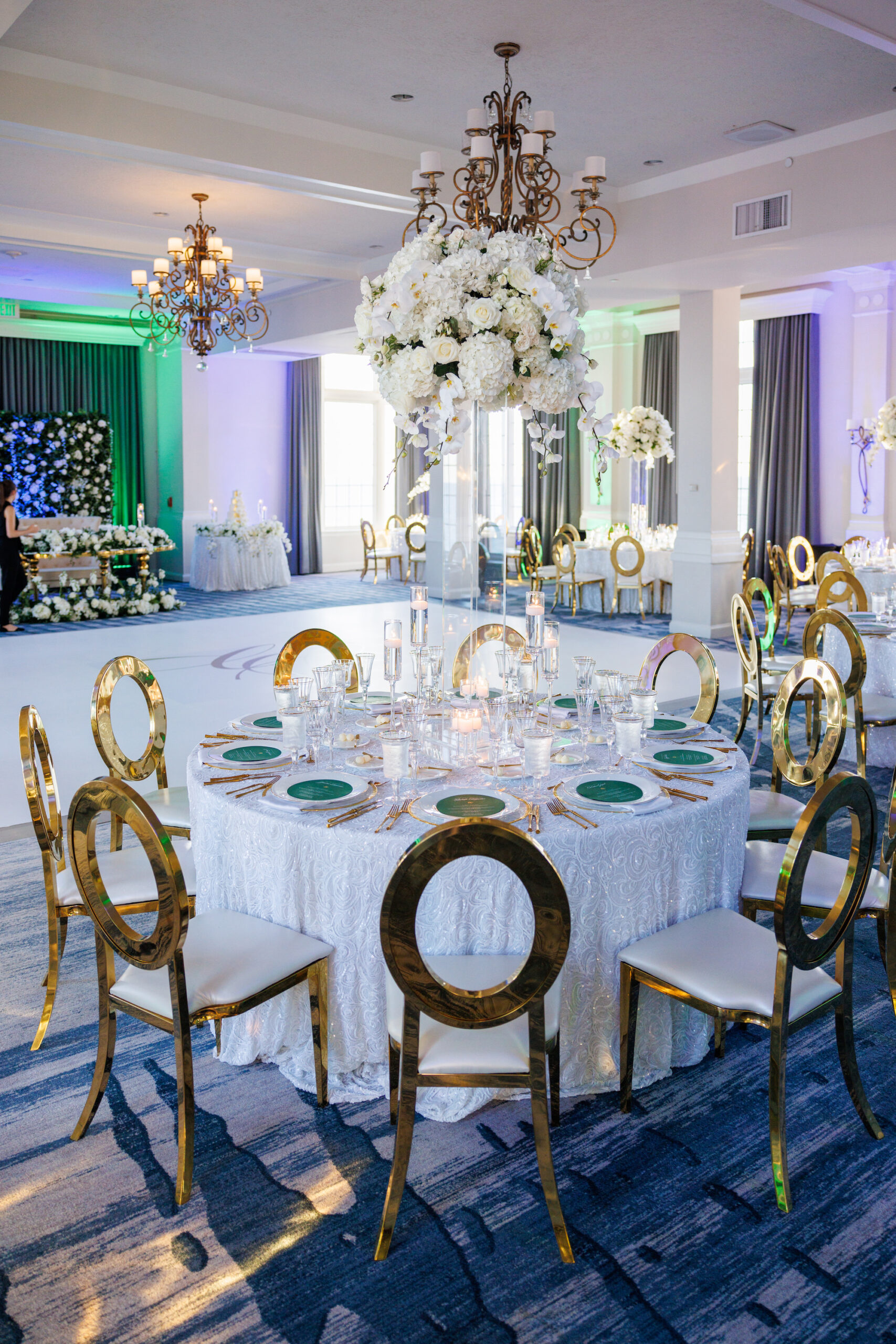 Modern Gold Chairs Seating Inspiration | Tall Acrylic Flower Stand Centerpiece Ideas Gold Rimmed Chargers with Gold Flatware and White Sequin Linen Inspiration | Emerald Green Menu Card Ideas
