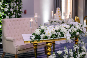 Luxurious Gold and White Curved Sweetheart Table with White Hydrangeas and Orchids with Ruscus Greenery Floral Arrangement Decor | Blush Tufted Bench Seat Ideas