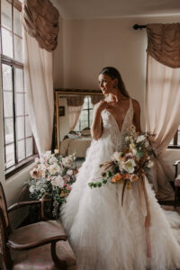 Bride Getting Ready in Bridal Suite Holding Bride Holding Burnt Orange and Greenery Boho Bridal Bouquet for Wedding Portrait