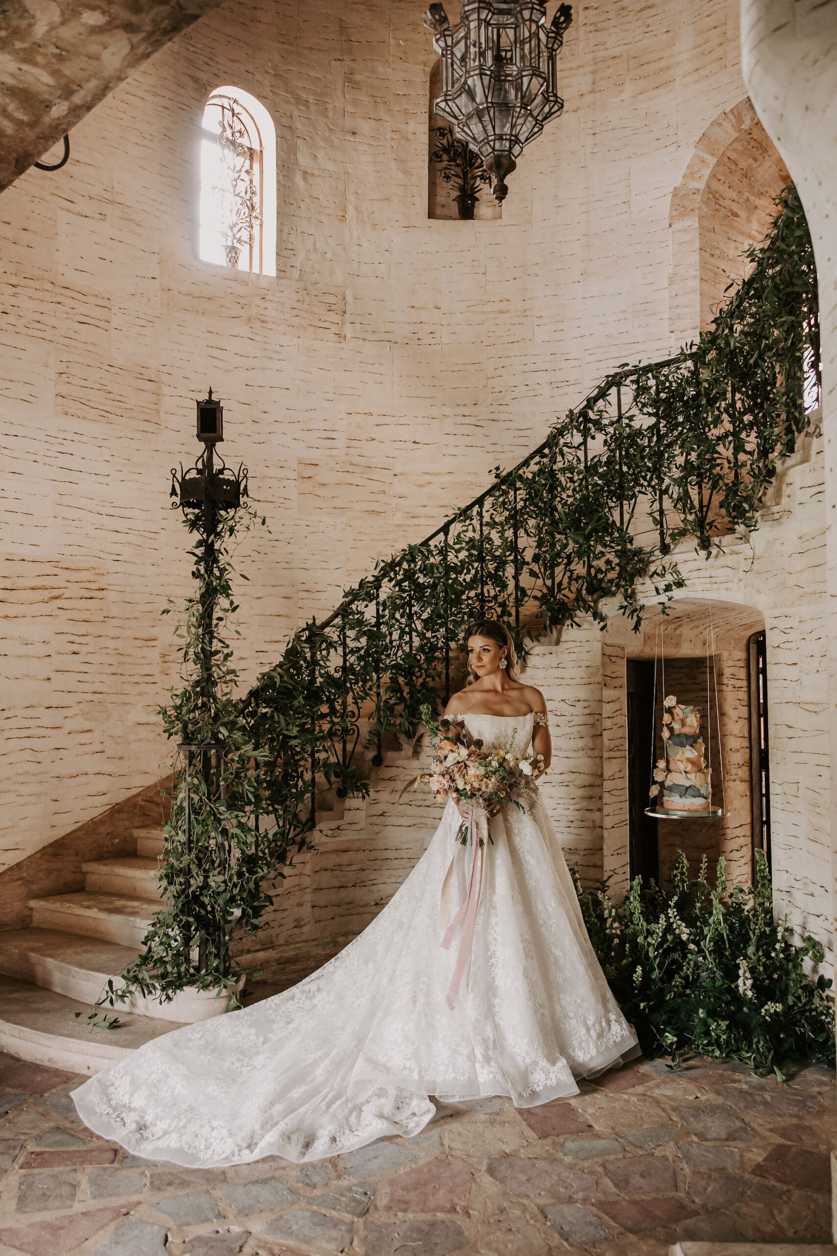 Bridal Portrait in Front of Grand Staircase Adorned with Greenery on Wedding Day