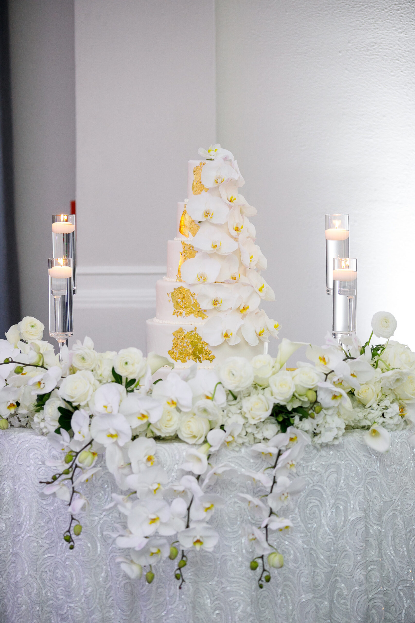 Luxurious Round Five-Tier Wedding Cake with Gold Foil and Orchids Luxurious White Dessert Table Ideas