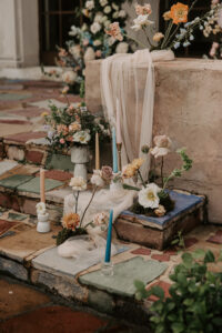 Whimsical Boho Wedding Decor with Multi Colored Candles and Muted Pastel Wedding Florals and Beige Sheer Linen | Ceremony Decor Ideas