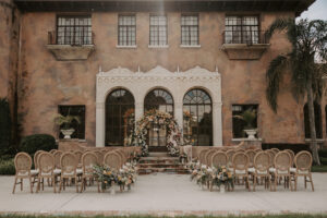 Wedding Ceremony at Italian Style Mansion with Garden Ombre Rainbow Floral Ceremony Arch and Rustic Boho Wooden Chairs | Decor Inspiration | Central Florida Venue Howey Mansion