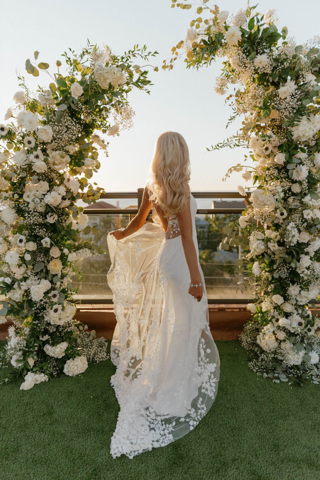 Bride in Illusion Lace Back Wedding Dress Golden Hour Wedding Portrait in Front of Floral Ceremony Arch Inspiration | St. Pete Beach Lemon Drops Weddings & Events