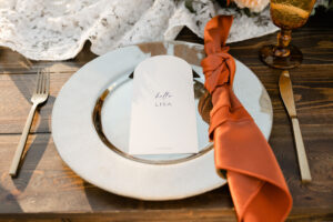 Arch Place Card with Gold Chargers and Flatware | Vintage Goblets | Burnt Orange Rust Napkins | Fall Wedding Reception Ideas | Lakeland Rentals A Chair Affair
