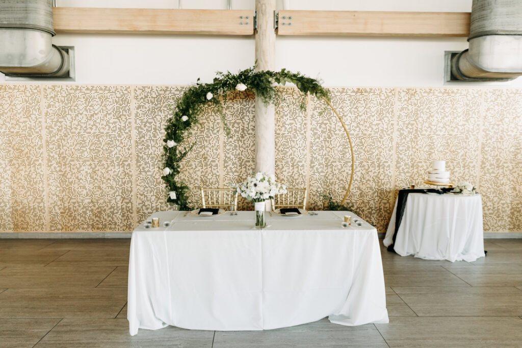 Modern Minimalist Round Gold Arch with Greenery and White Roses Wedding Reception Sweetheart Table Inspiration