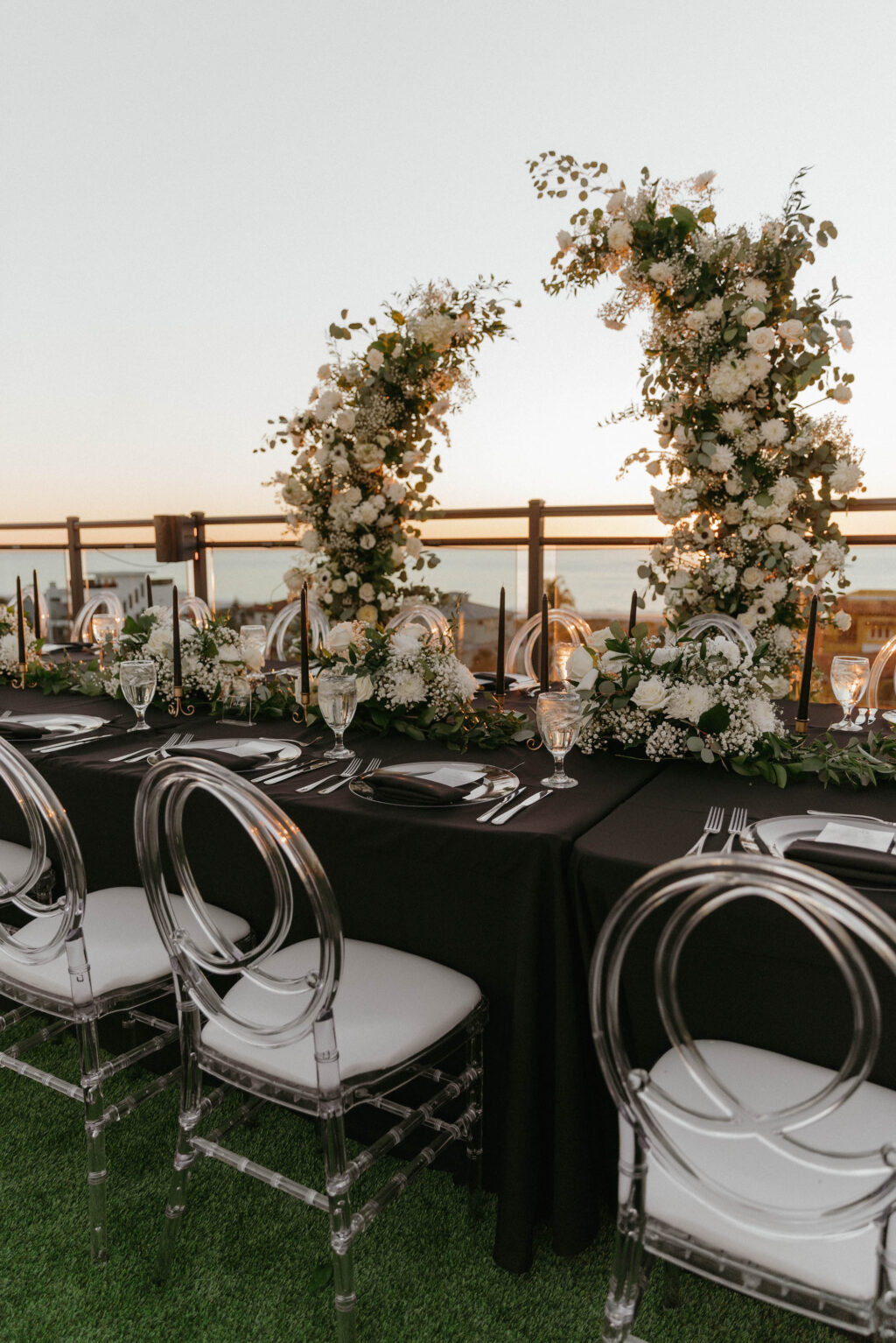 Infinity Ghost Chairs with Silver Flatware with White Florals and Greenery Reception Inspiration | St. Pete Beach Outside the Box Rental Linens | Florist Lemon Drops Weddings and Events
