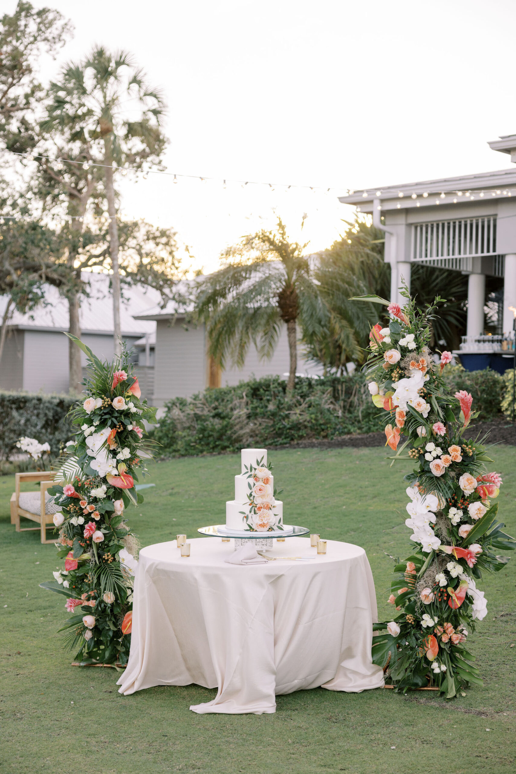 Tropical Wedding Cake Table Ideas | Tall Asymmetrical Stands with Pink, Orange, and White Flowers | Sarasota Florist Beneva Weddings and Events