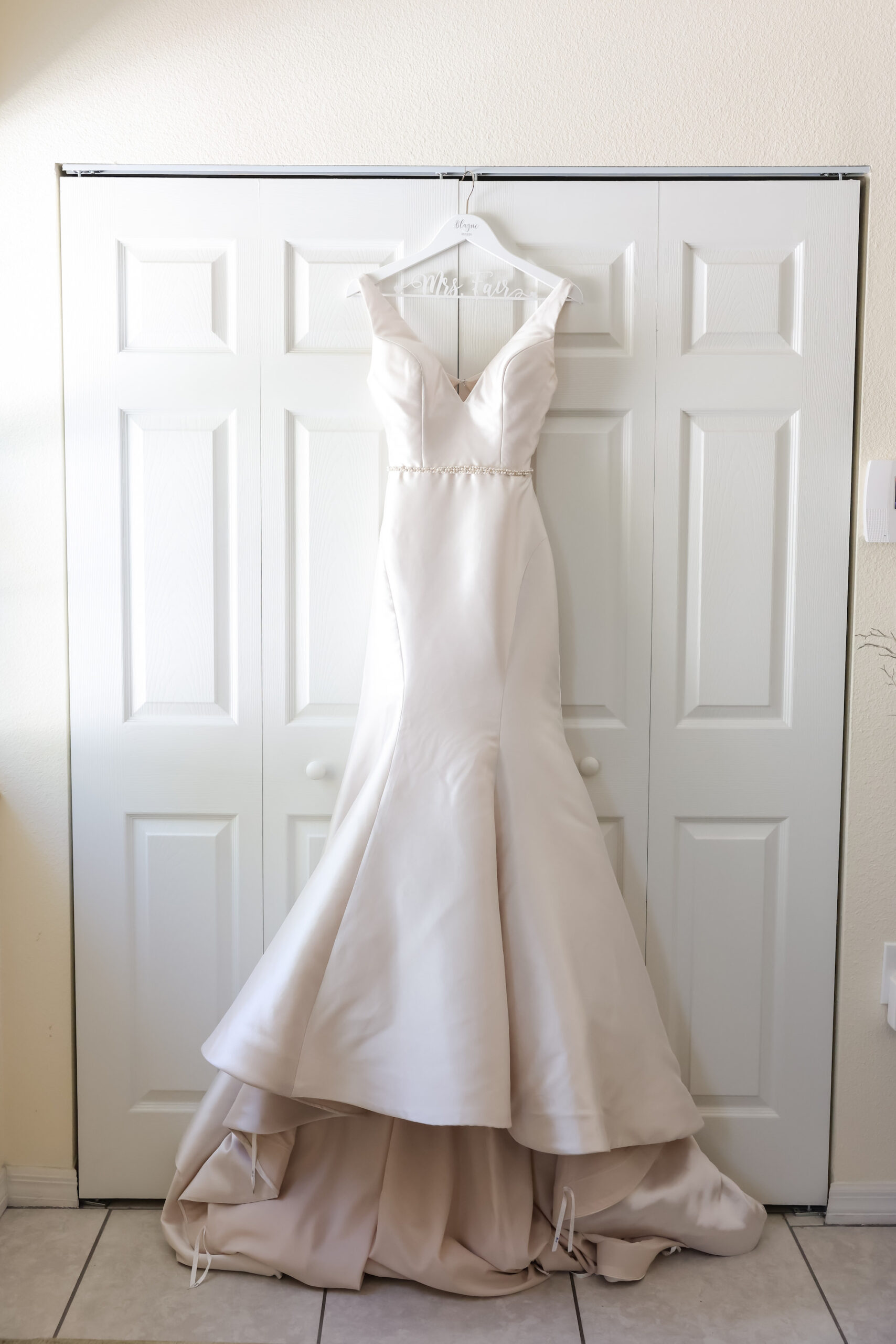 Madison James White Deep V Neck Fit and Flare Satin Wedding Dress Hanging Portrait
