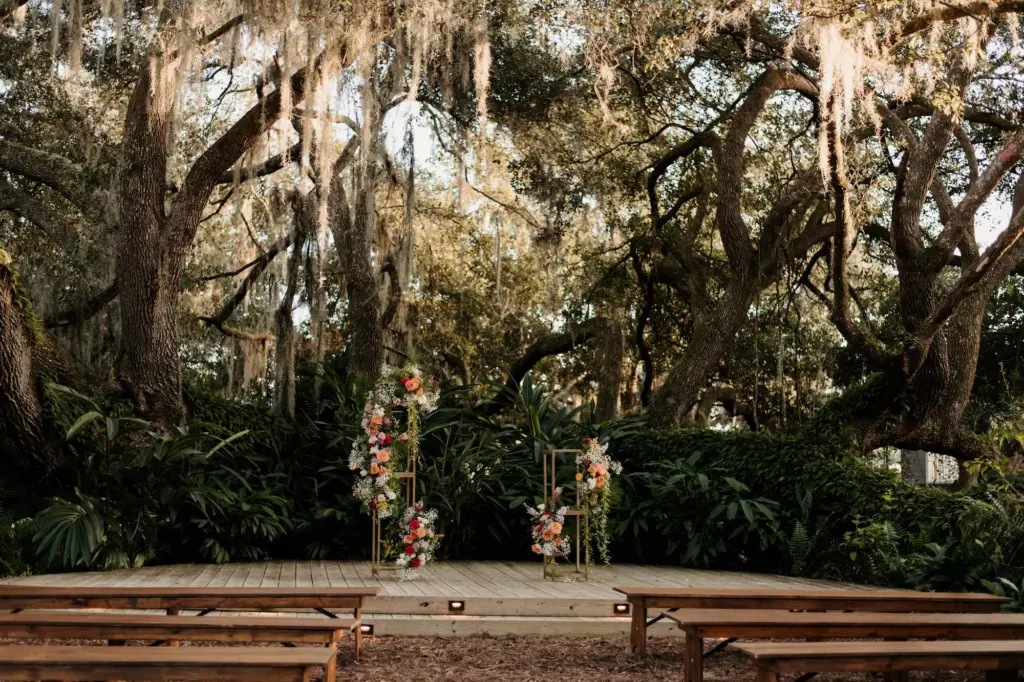 Whimsical Garden Wedding Ceremony with Bench Seating and Floral and Gold Stand Arch Decor Ideas | Tampa Wedding Venue Mill Pond Estates