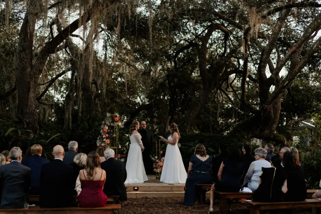 LGBTQ+ Couples Exchanging Vows in Garden Inspired Wedding Ceremony | Tampa Wedding Venue Mill Pond Estates