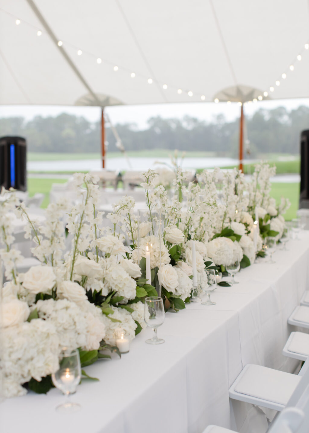 Classic White Stock, Garden Roses, and Hydrangeas Feasting Table Centerpieces | Sailcloth Tent | White Folding Garden Chairs | Timeless Wedding Reception Inspiration