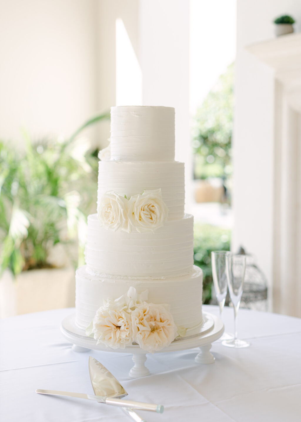 Classic Four-Tiered Round Buttercream Textured Wedding Cake with White Garden Rose Accents