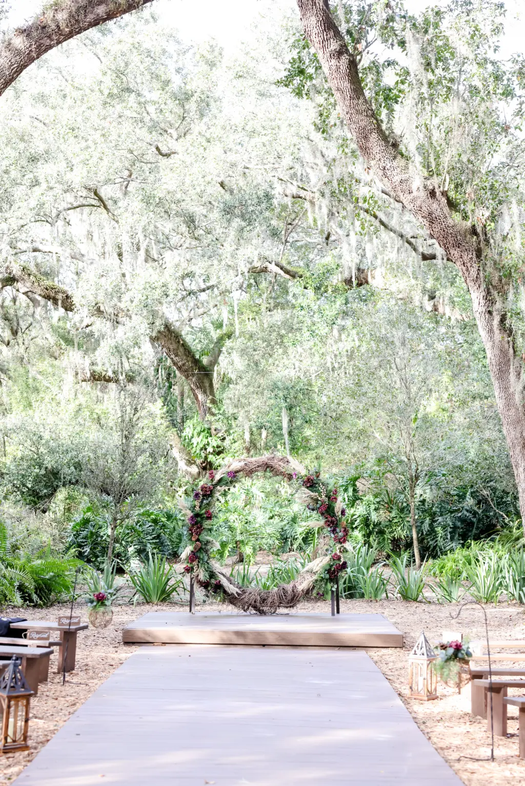 Round Arch with Wrapped Vines, Pinecones, Burgundy and Purple Flowers, and Greenery for Wedding Ceremony Inspiration