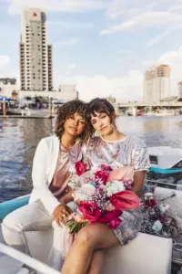Waterfront Same Sex Wedding Couple Boat Portrait with Bright Floral Inspiration | Tampa Wedding Planner Wilder Mind Events