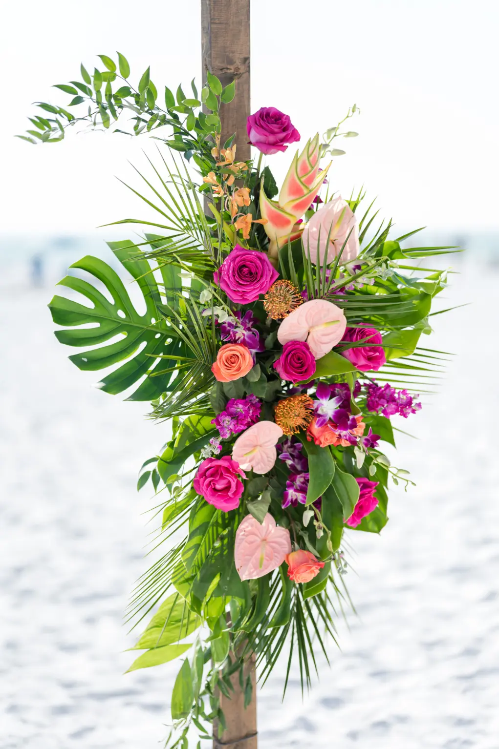 Wooden Tropical Inspired Ceremony Arch with Monstera Leaves and Pink and Orange Florals Ideas | Sarasota Florist Save the Date Florida