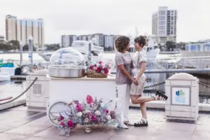 Same Sex Couple at Intimate Elopement with Cotton Candy Machine Decorated with Bright Pink Florals and Baby's Breath Wedding Decor Inspiration | Tampa Wedding Planner Wilder Mind Events