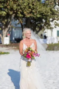 Bride Walking Down the Aisle In Beach Wedding Holding Bright Tropical Florals Portrait | Tampa Florist Save the Date Florida