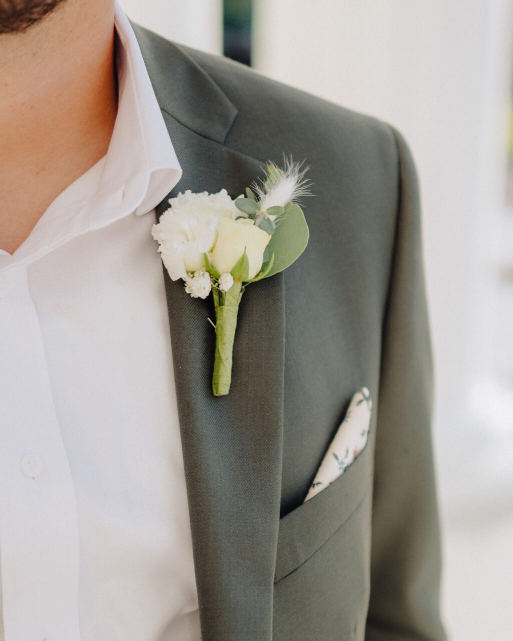 White Carnation, Babies Breath, Rose, and Eucalyptus Boutonniere with Feather Inspiration | Groom Olive Green Suit Ideas