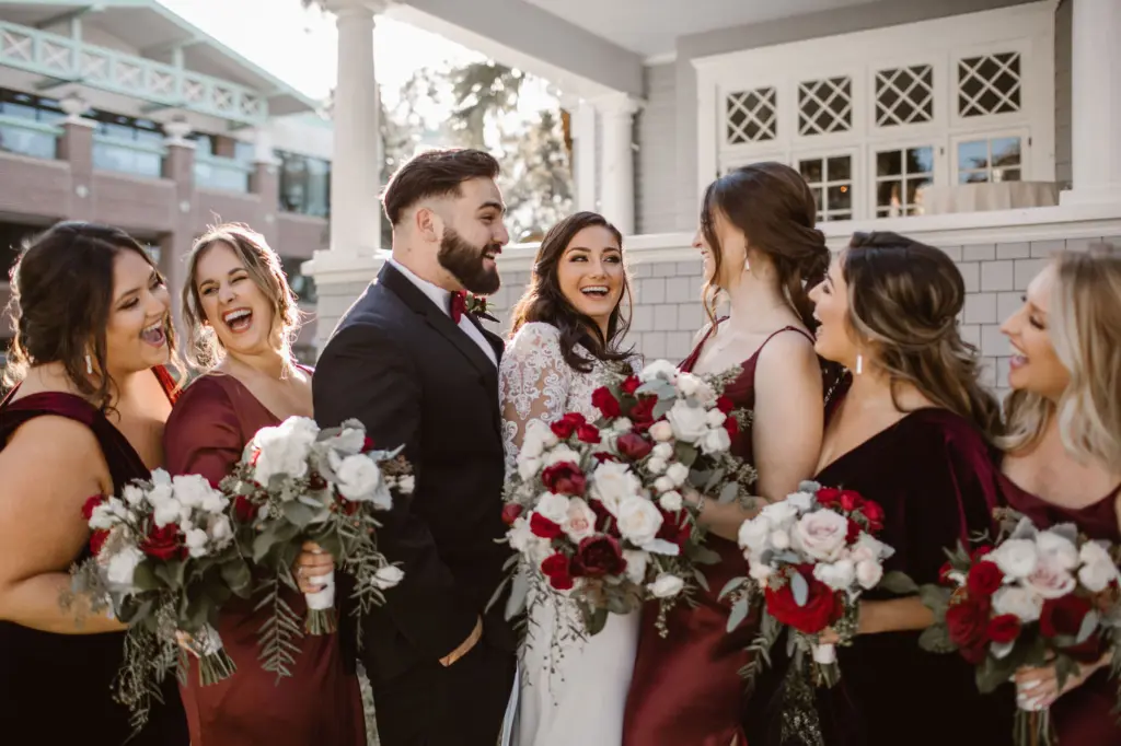 Mismatching Burgundy Bridesmaid Wedding Dresses with Man of Honor | White and Red Roses with Greenery Bouquet Inspiration