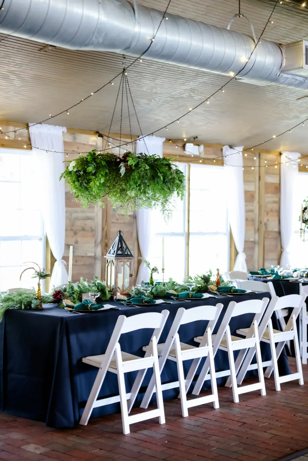 Hanging Greenery Chandelier with Dark Green Linen with White Folding Garden Chairs | Earthy Wedding Reception Inspiration
