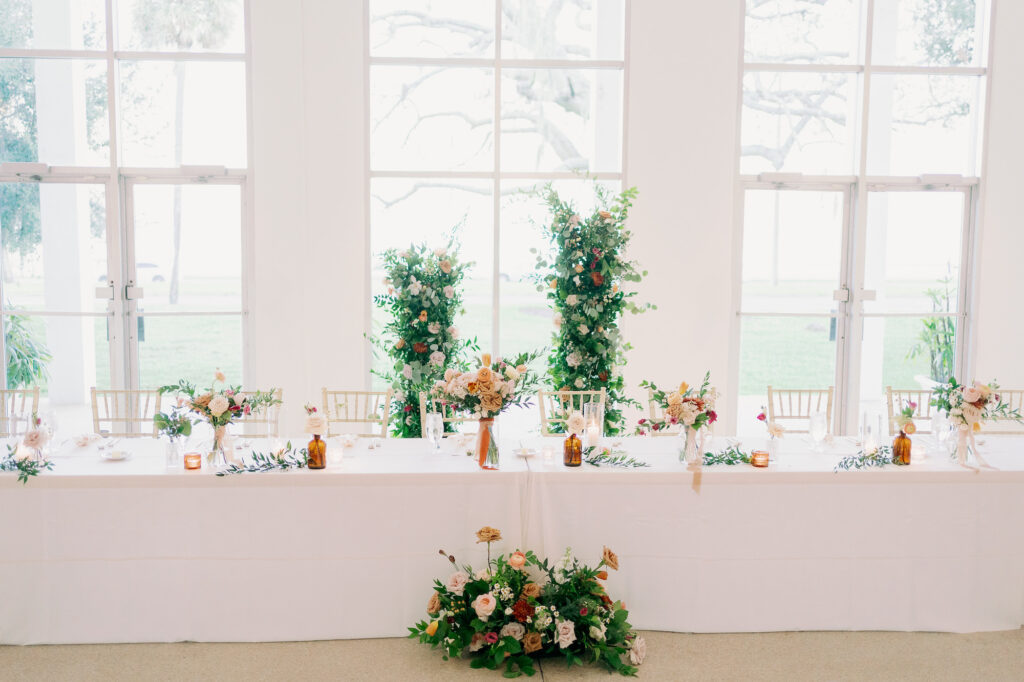 Asymmetrical Rose and Greenery Backdrop for Fall Garden Wedding Reception Head Table Inspiration | Bridal Party Feasting Table with Floor Flower Arrangement | Tampa Bay Kate Ryan Event Rentals | Planner Kelly Kennedy Weddings & Events | Venue Tampa Garden Club