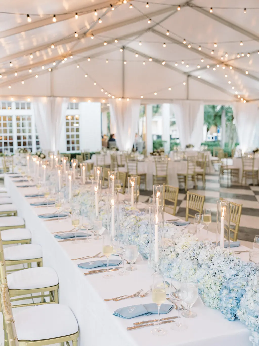 Classic Blue and White Hydrangea Garland Centerpiece with Taper Candles Inside Hurricane Glass Tube for Feasting Table | Classic Blue and White Tented Wedding Reception Inspiration | Tampa Bay Florist Save The Date Florida | Planner EventFull Weddings