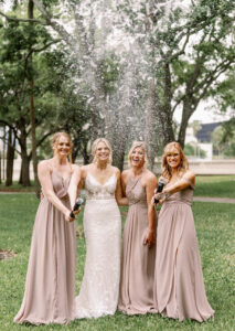 Bride and Bridesmaids with Glitter Confetti Cannons Wedding Portrait | Neutral Taupe Dusty Rose Bridesmaids Dress Inspiration | Photographer Dewitt for Love Photography | Videographer Shannon Kelly Films
