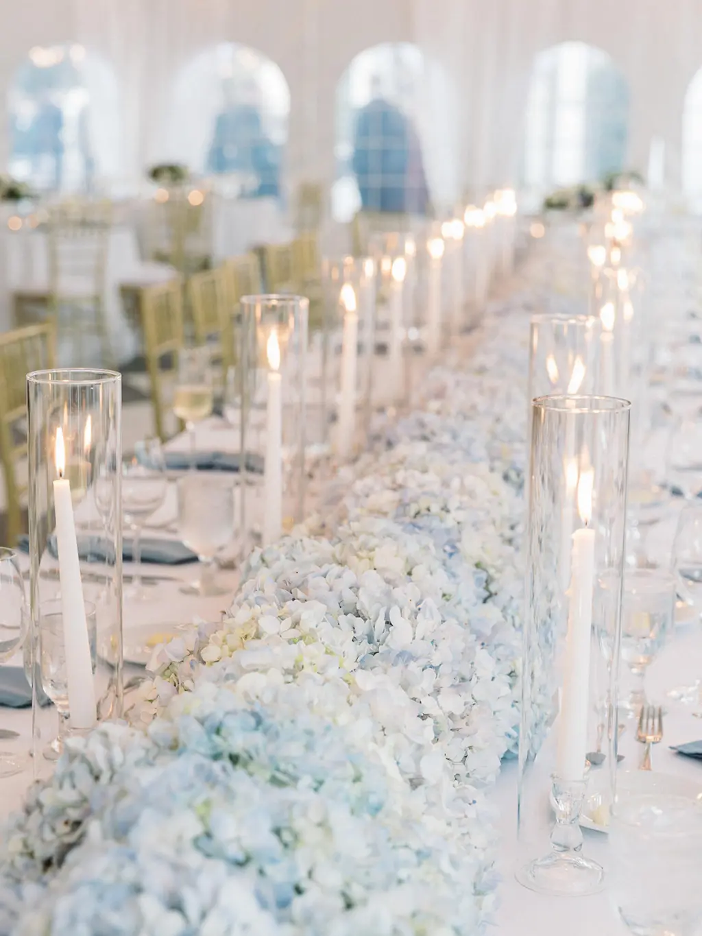 Classic Blue and White Hydrangea Garland Centerpiece with Taper Candles Inside Hurricane Glass Tube for Feasting Table | Classic Blue and White Wedding Reception Inspiration | Tampa Bay Florist Save The Date Florida