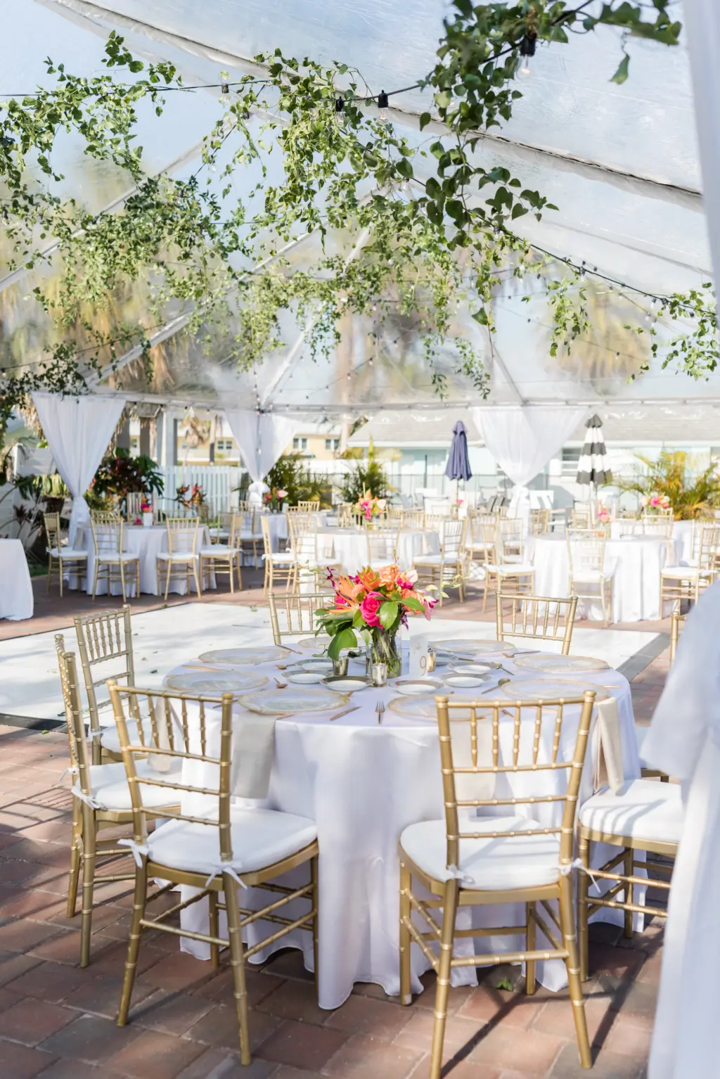 Tented Tropical Beach Wedding Reception Ideas with Greenery and Pops of Color | Gold Chiavari Chairs with White Linen Rounds | Wedding Planner MDP Events Tampa Florida