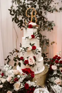 Round Four-tiered Buttercream Wedding Cake with White and Burgundy Rose Accents | Gold Initial Cake Topper Ideas