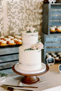 Two-tiered Semi-Naked Wedding Cake with Blush Roses and Greenery Accents | Personalized Name Cake Topper | Tampa Bay Cake Company
