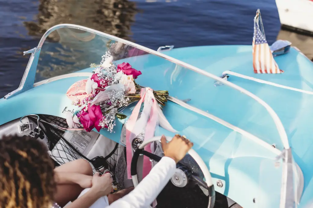 Retro Blue Boat Elopement Couple Driving Off With with Bright Pink Florals and Baby's Breath Wedding Decor Inspiration | Tampa Wedding Planner Wilder Mind Events