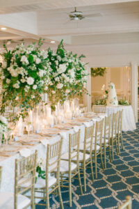 Tall Gold Flower Stand with White Flowers and Greenery Centerpiece Ideas | Gold Chiavari Chairs| Timeless Candlelit Wedding Reception | Tampa Bay Rentals A Chair Affair | Kate Ryan Event Rentals | Clearwater Venue Carlouel Beach & Yacht Club
