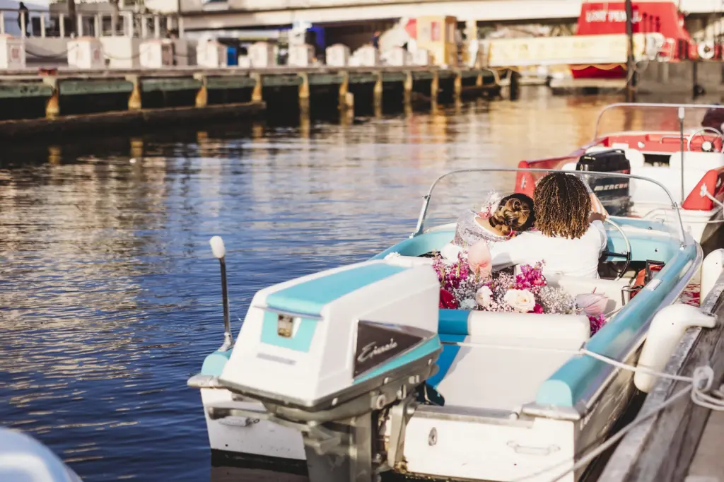Throwback Blue Boat Elopement Couple Driving Off With with Bright Pink Florals and Baby's Breath Wedding Decor Inspiration | Tampa Wedding Planner Wilder Mind Events