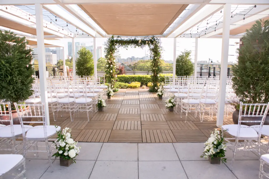 Covered Rooftop Wedding Ceremony Ideas | Arch Backdrop with Greenery | Clear Chiavari Chairs | Tampa Bay Kate Ryan Event Rentals | Rooftop 220 by Armature Works